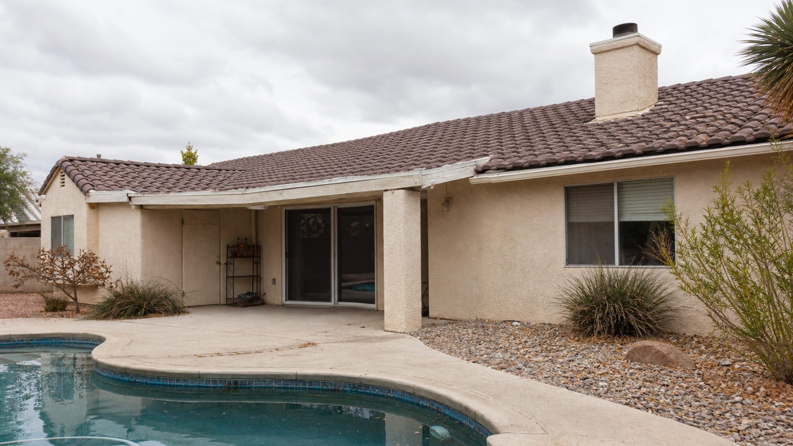 Nevada residential exterior with xeriscape, dry-air weathering, pool patio materials, muted afternoon light